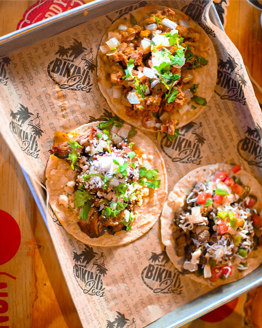 Three street tacos on a tray at Cabo Joe's